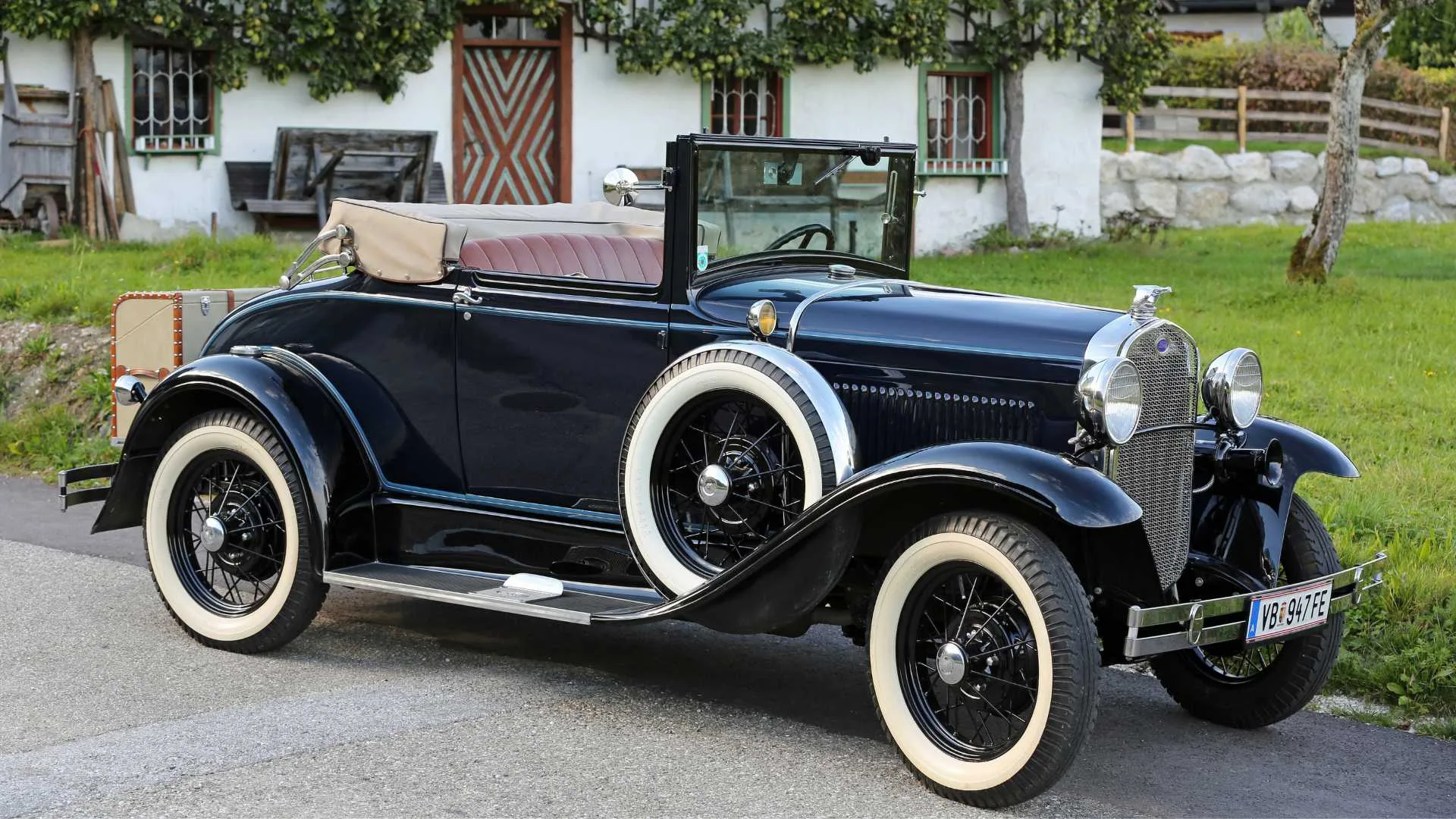 An black vintage car parked on the side of the road.