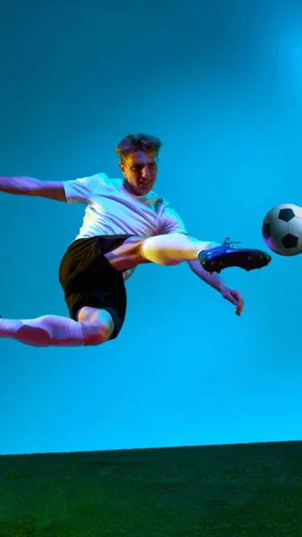 A football player kicking a football in the air iPhone wallpaper