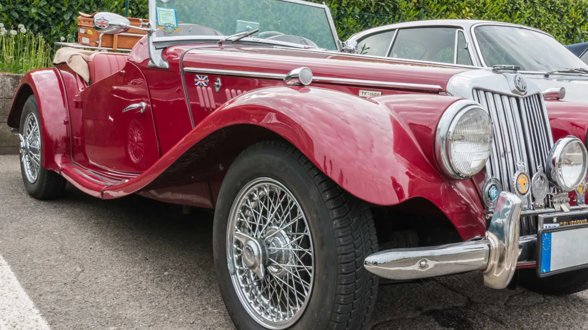 A classic red sports car parked in the parking lot