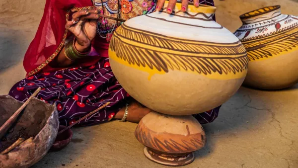 Indian woman painting vases in her workshop, Rajasthan, India